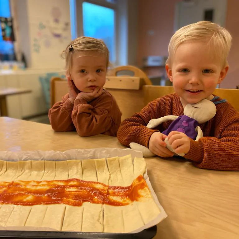 Vrolijke kinderen bij Kindcentrum Pi met begeleider